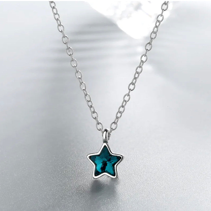 A sterling silver necklace with a blue star-shaped pendant on a chain.