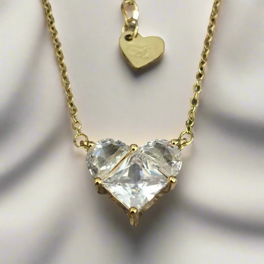 Gold necklace with a large clear gemstone on a wooden surface