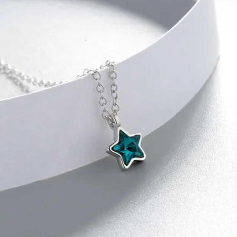 Star-shaped pendant necklace with blue gemstone on a white background