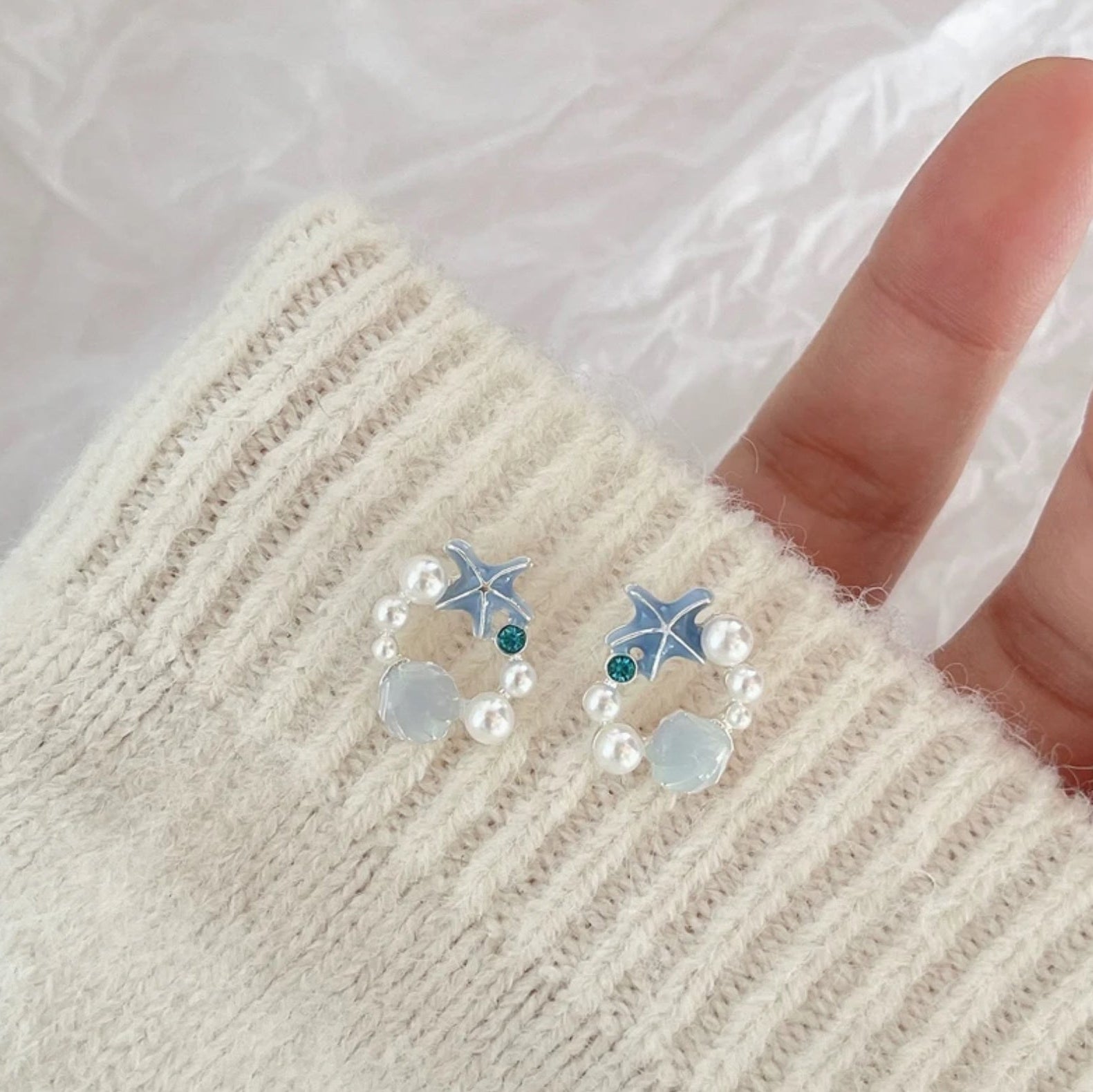 Woman holding the Starfish Seashell Pearl Earrings