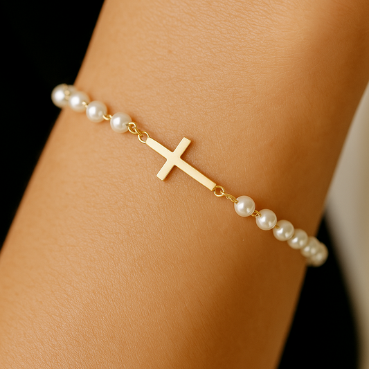 Gold Cross Pearl Bracelet/Anklet on a wrist against a black background