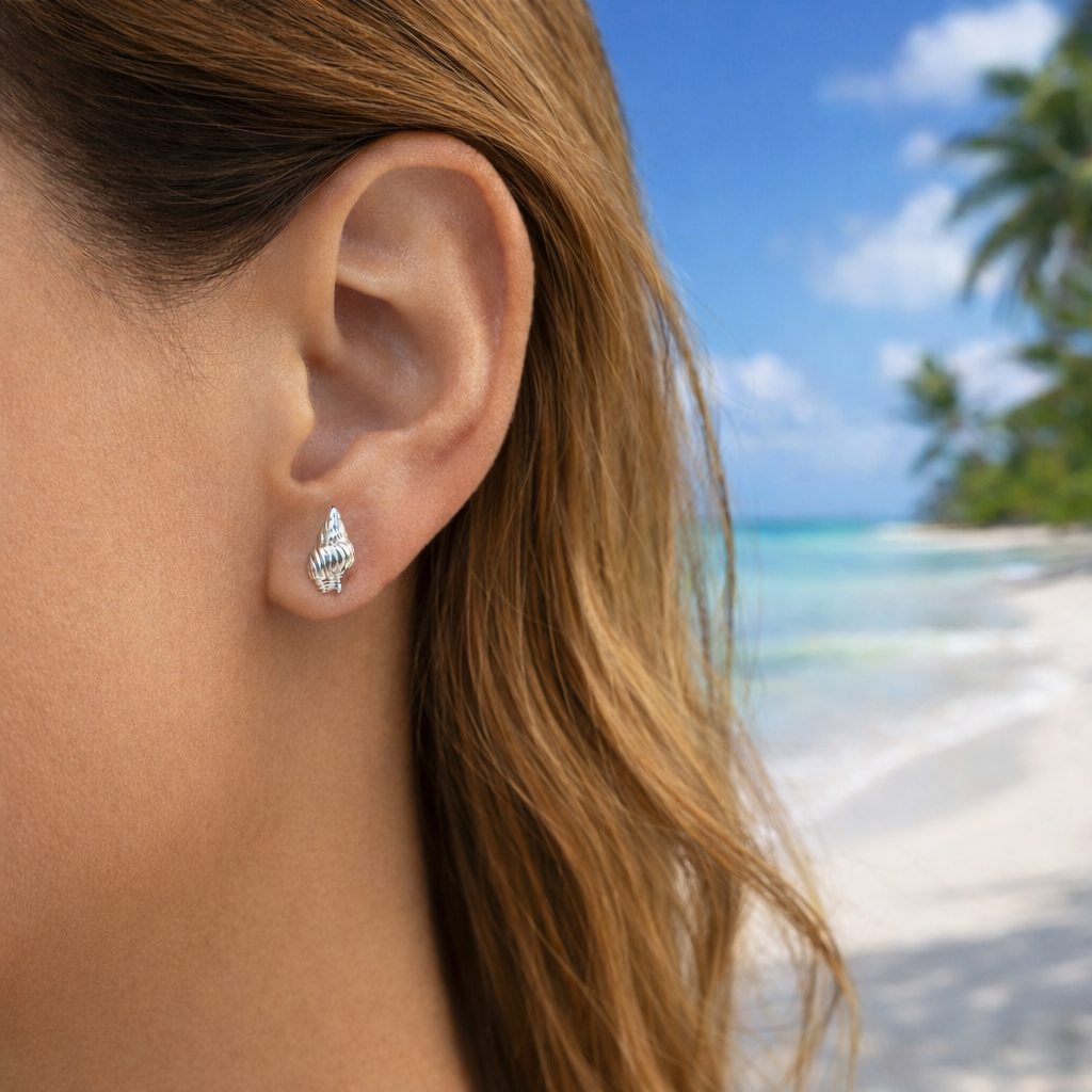 Silver Seashell Earrings worn by a person with a beach background