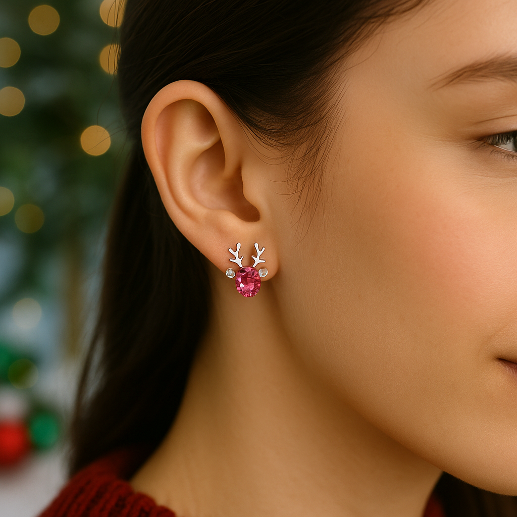 Close-up of a woman wearing Crystal Pink Reindeer Earrings with antlers against a blurred festive background.