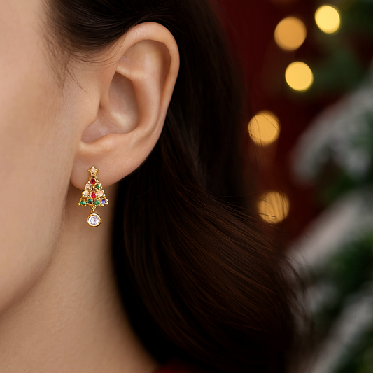 Close-up of an ear wearing a Twinkling Christmas Tree Earring with a blurred festive background