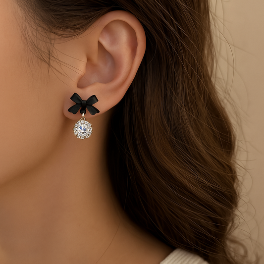 Close-up of a woman wearing a Black Bow Crystal Drop Earring on a neutral background