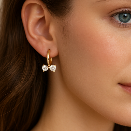 Close-up of a woman wearing Gold Zircon Bow Hoop Earrings with clear gemstones.