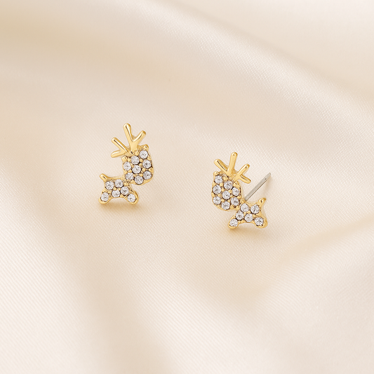 Zircon Reindeer Earrings with clear gemstones on a beige satin background