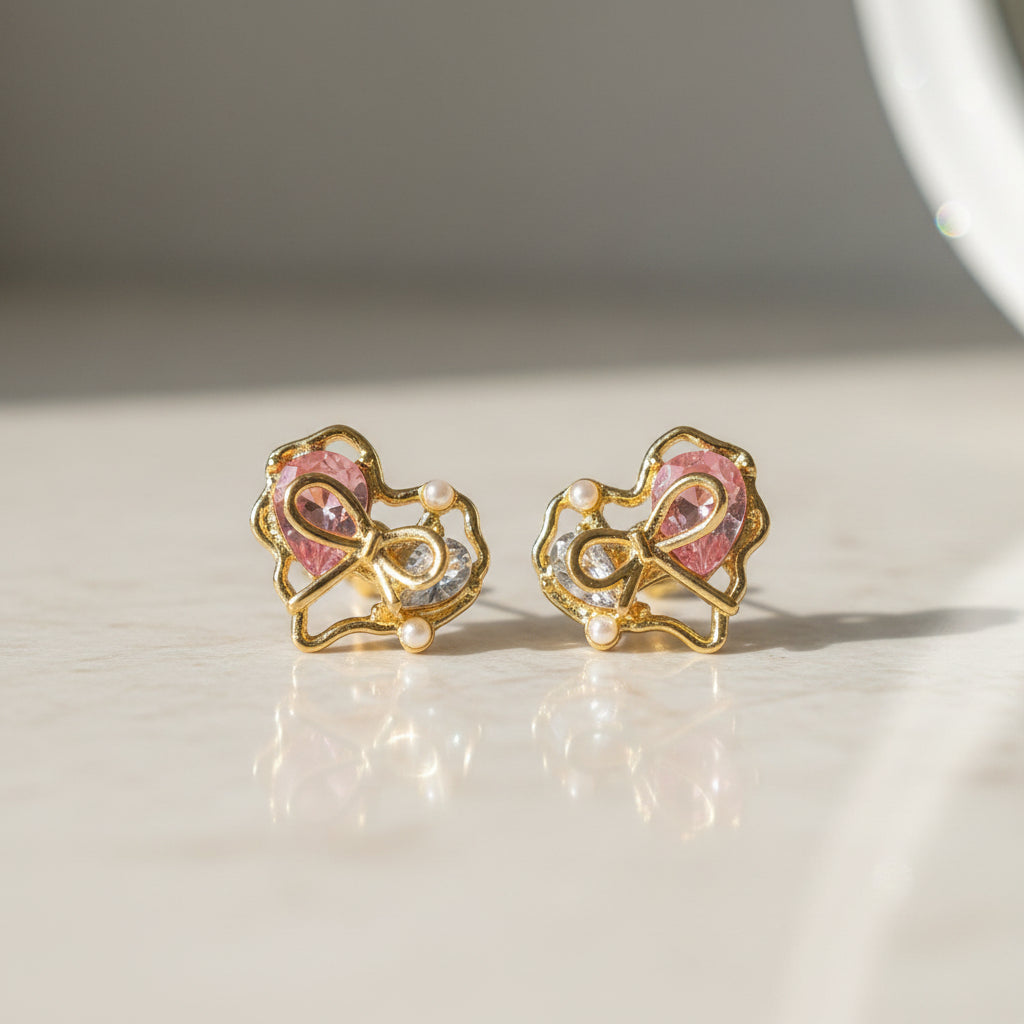 Crystal Bow Heart Earrings on marble surface
