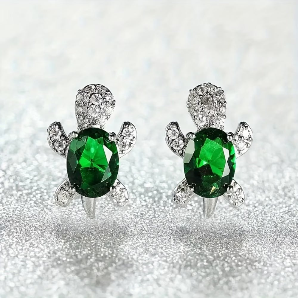 Emerald Green Crystal Turtle Earrings on a glittery background