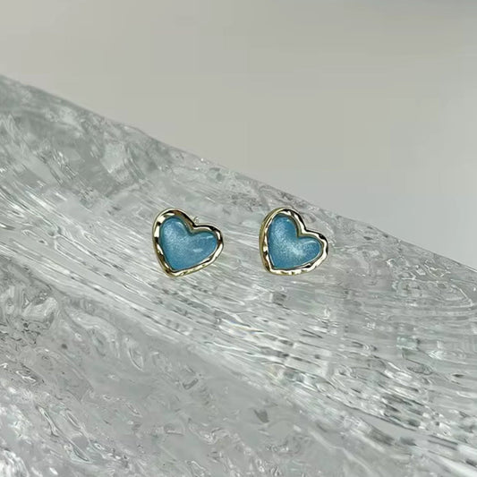 Aqua Blue Heart Earrings on a textured white surface