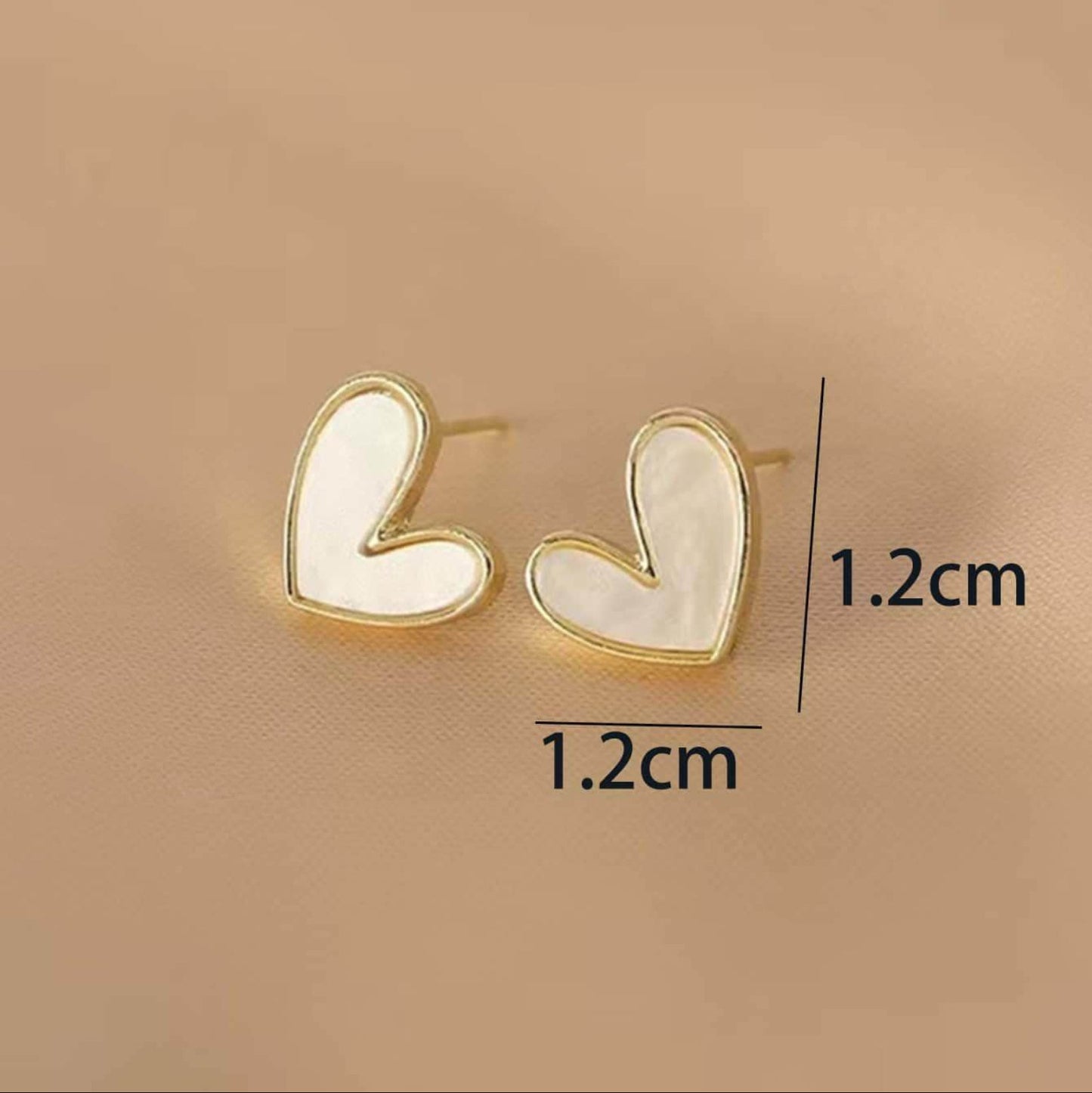White heart earrings on a beige background, showing measurement details.