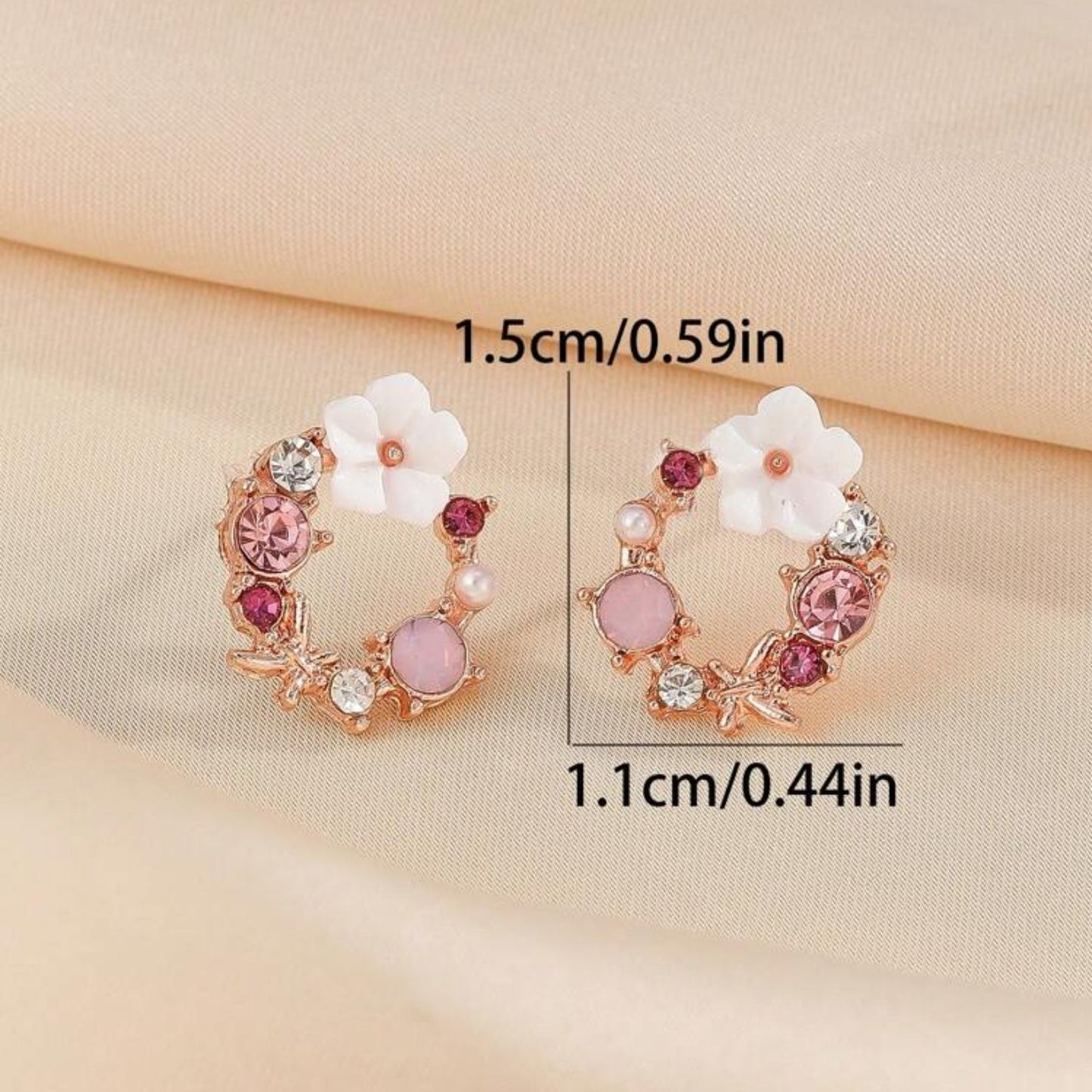 Pink & White Flower Wreath Earrings with gemstones on a beige fabric background, showing measurements.