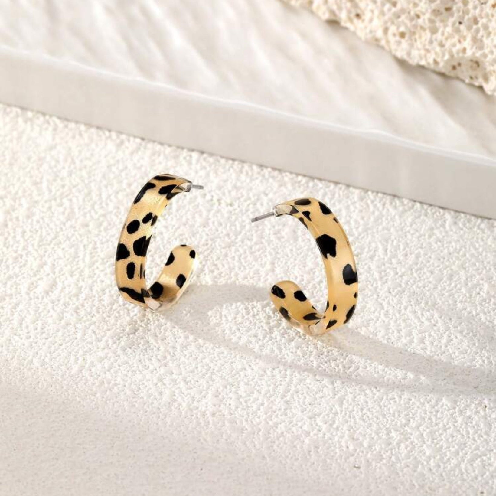 Leopard print hoop earrings on a white surface