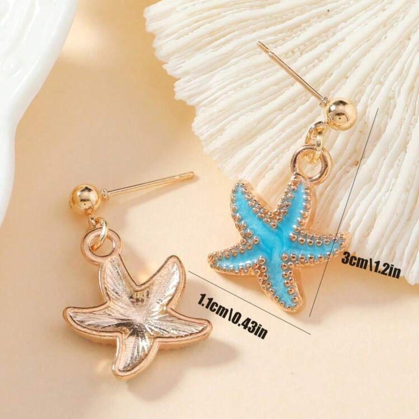 Starfish-shaped earrings with gold and blue details on a shell background