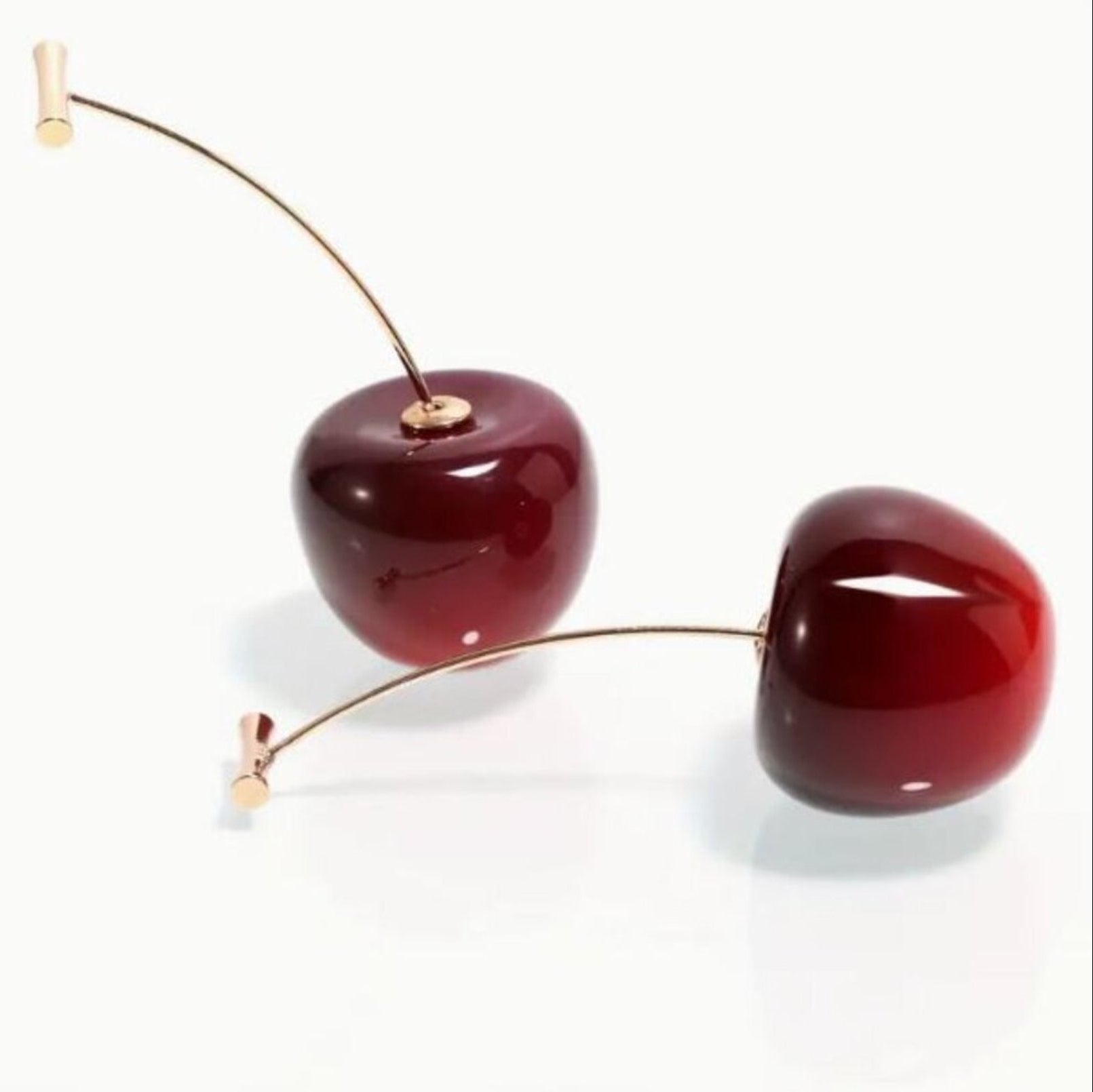 Pair of cherry-shaped earrings on a white background
