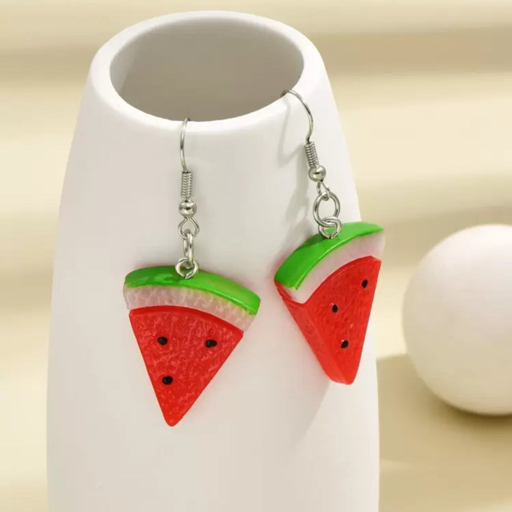 Silver dangle earrings shaped like watermelon slices with red, green, and black enamel accents