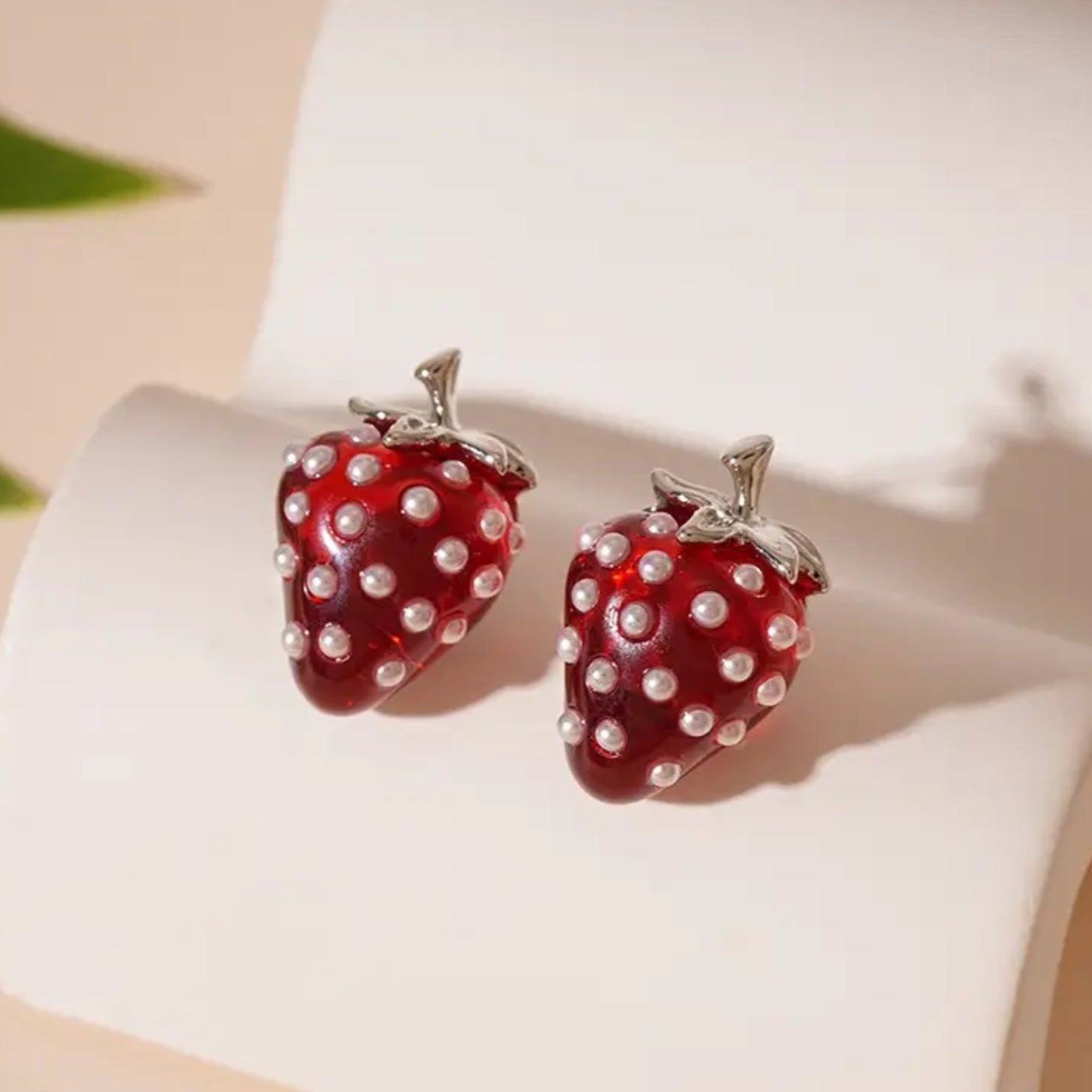 Strawberry Pearl Earrings: Strawberry-shaped earrings with pearl details on a white surface