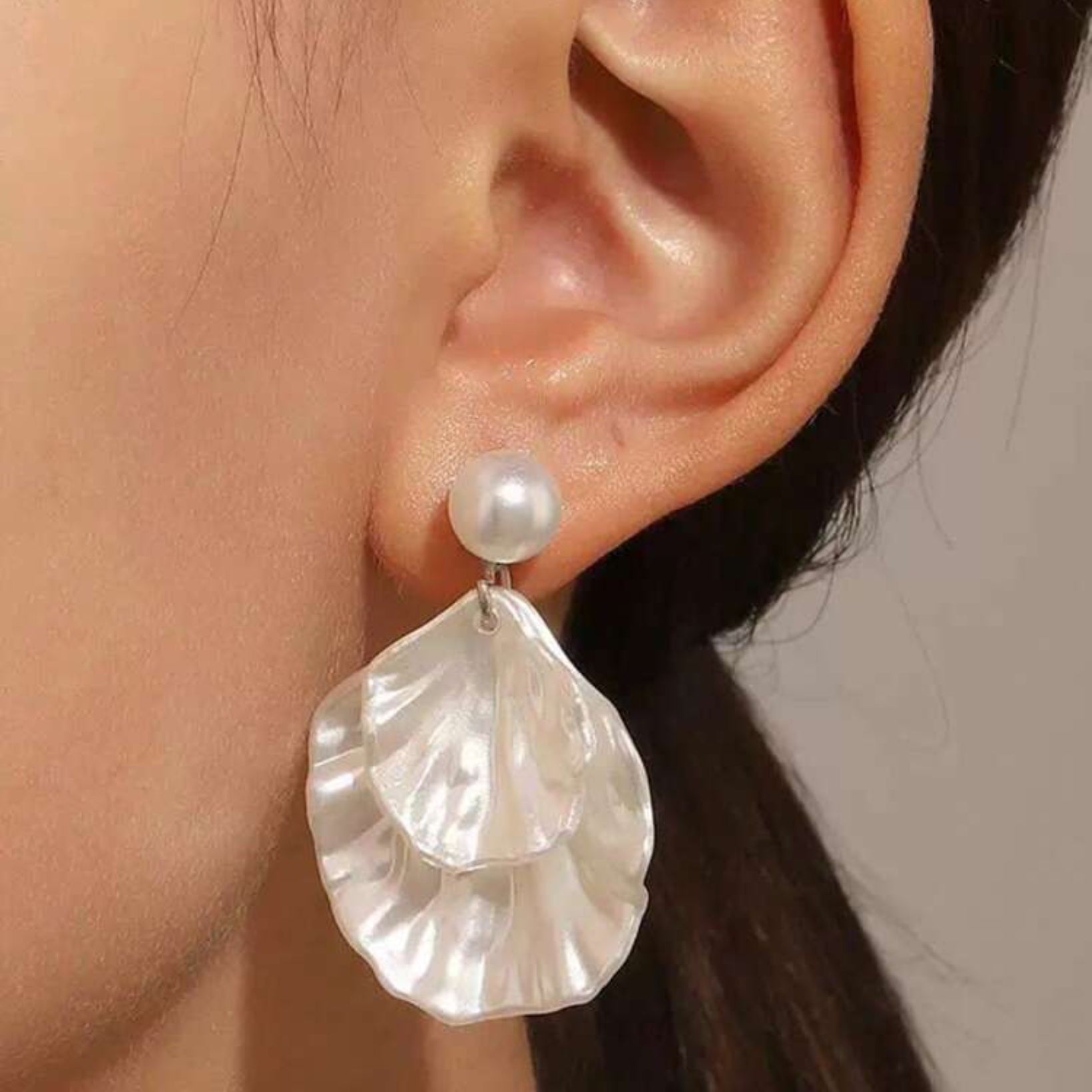 Pearl earring worn by a person with a neutral background