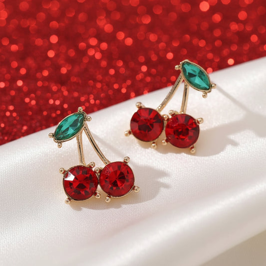 Gold cherry-shaped stud earrings with red gem stones and green enamel leaf accents