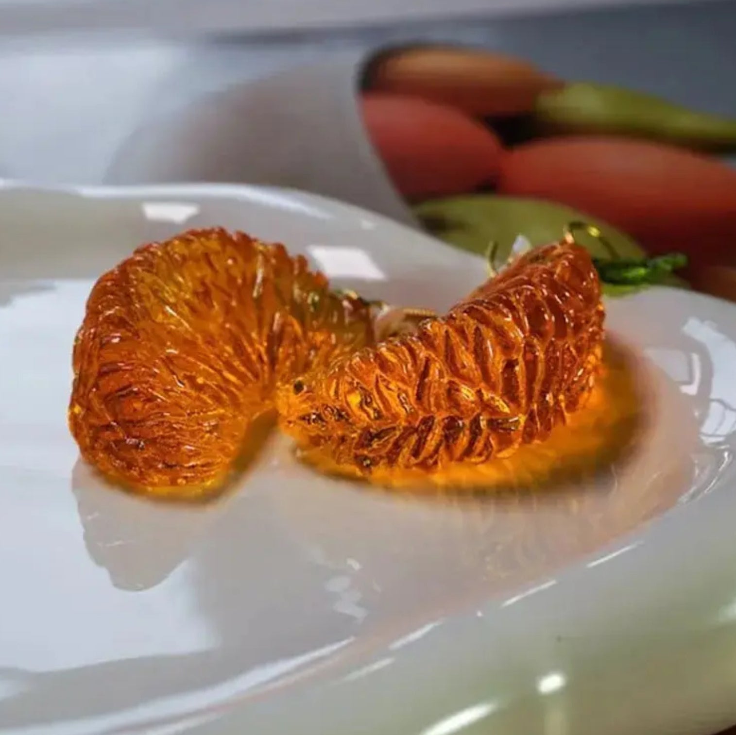 Two orange slices on a white plate with a blurred background