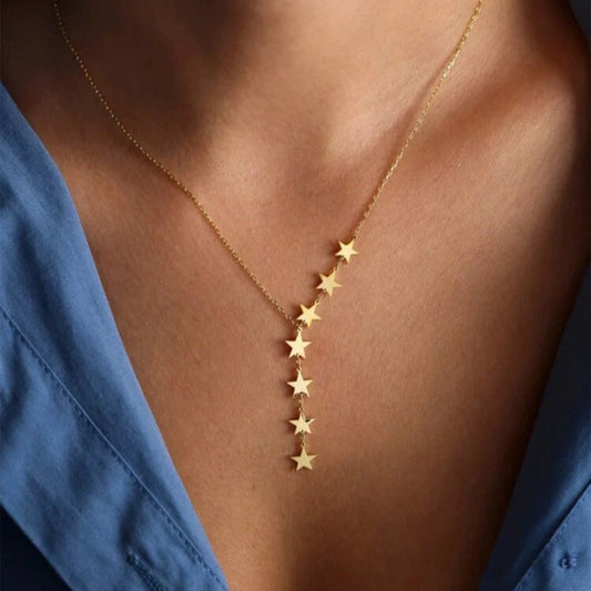 Gold star necklace on a person wearing a blue shirt