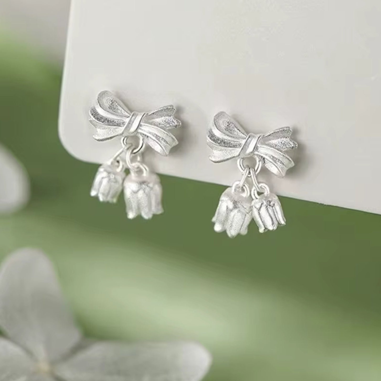 Gold bow earrings with delicate bellflower-shaped dangles