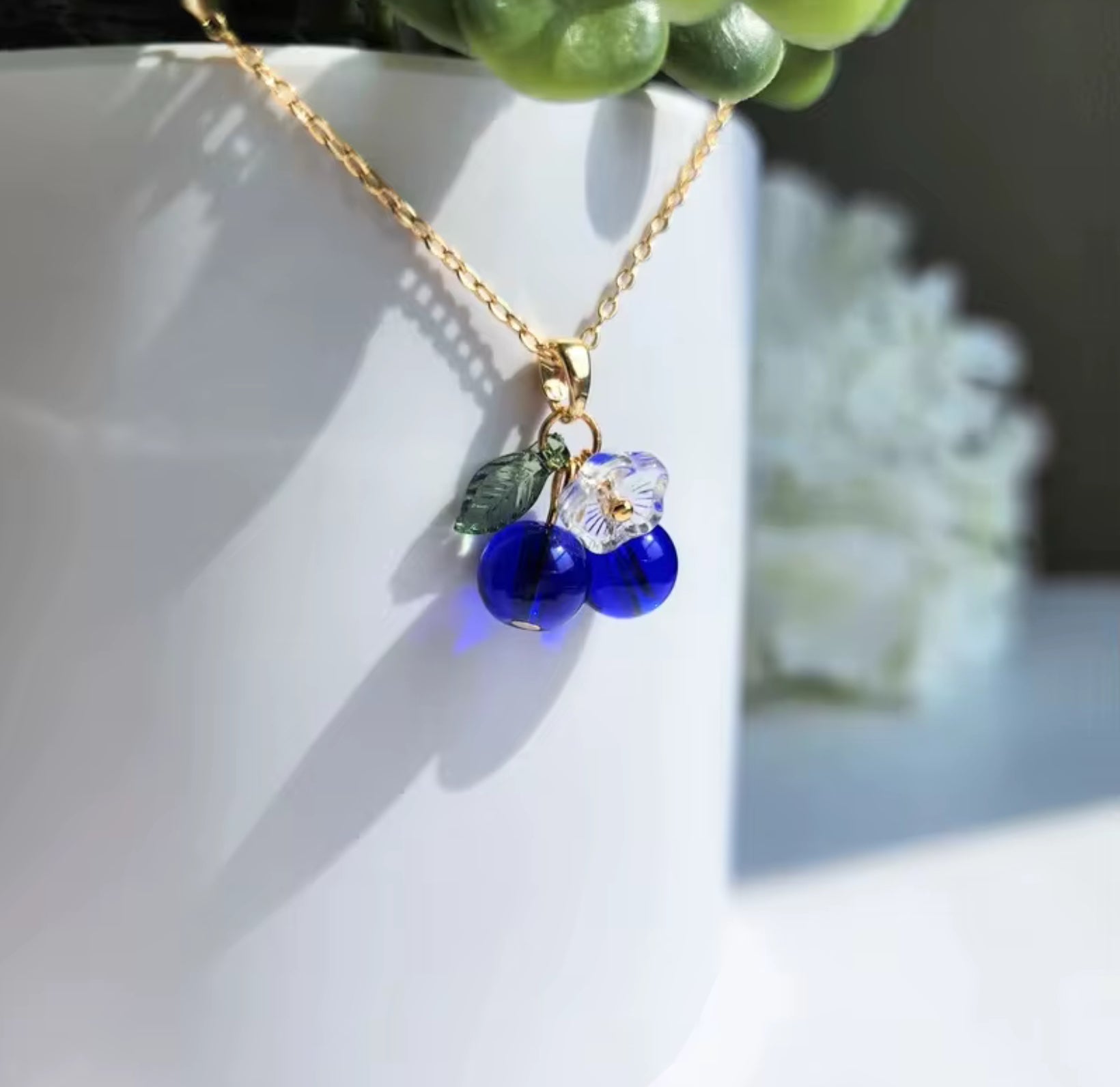 Gold necklace with small blueberry flower charms