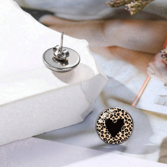 Leopard print earring with black heart design on a white surface