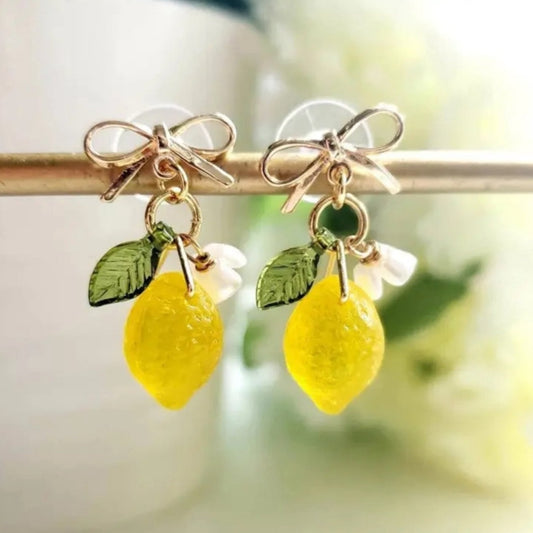 Gold bow stud earrings with dangling lemon accents