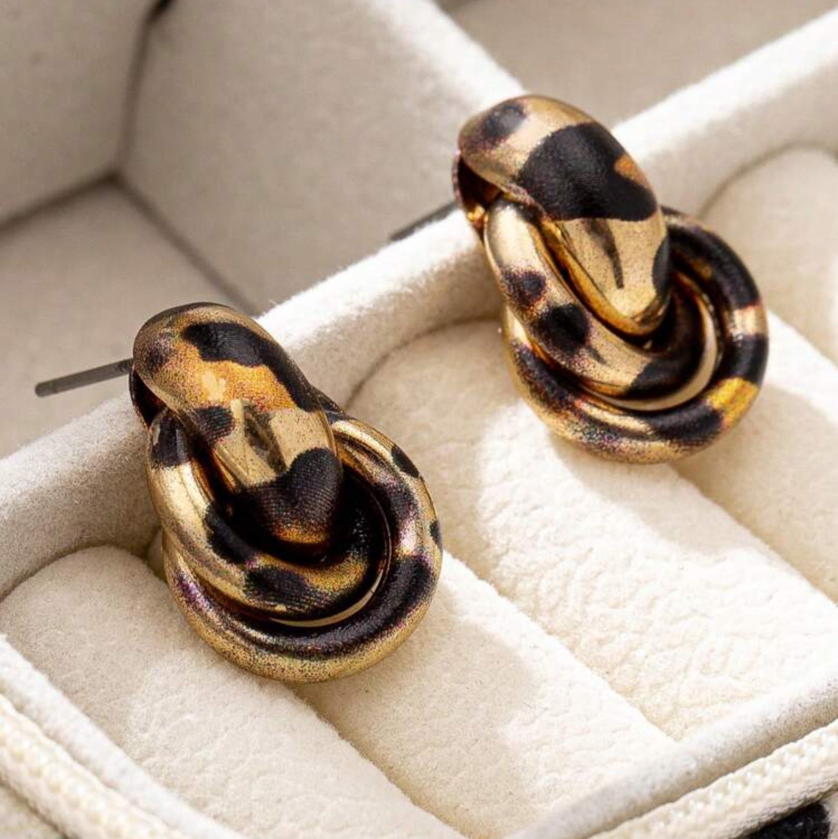 Pair of Leopard Circle Knot Earrings on a white jewelry display box.