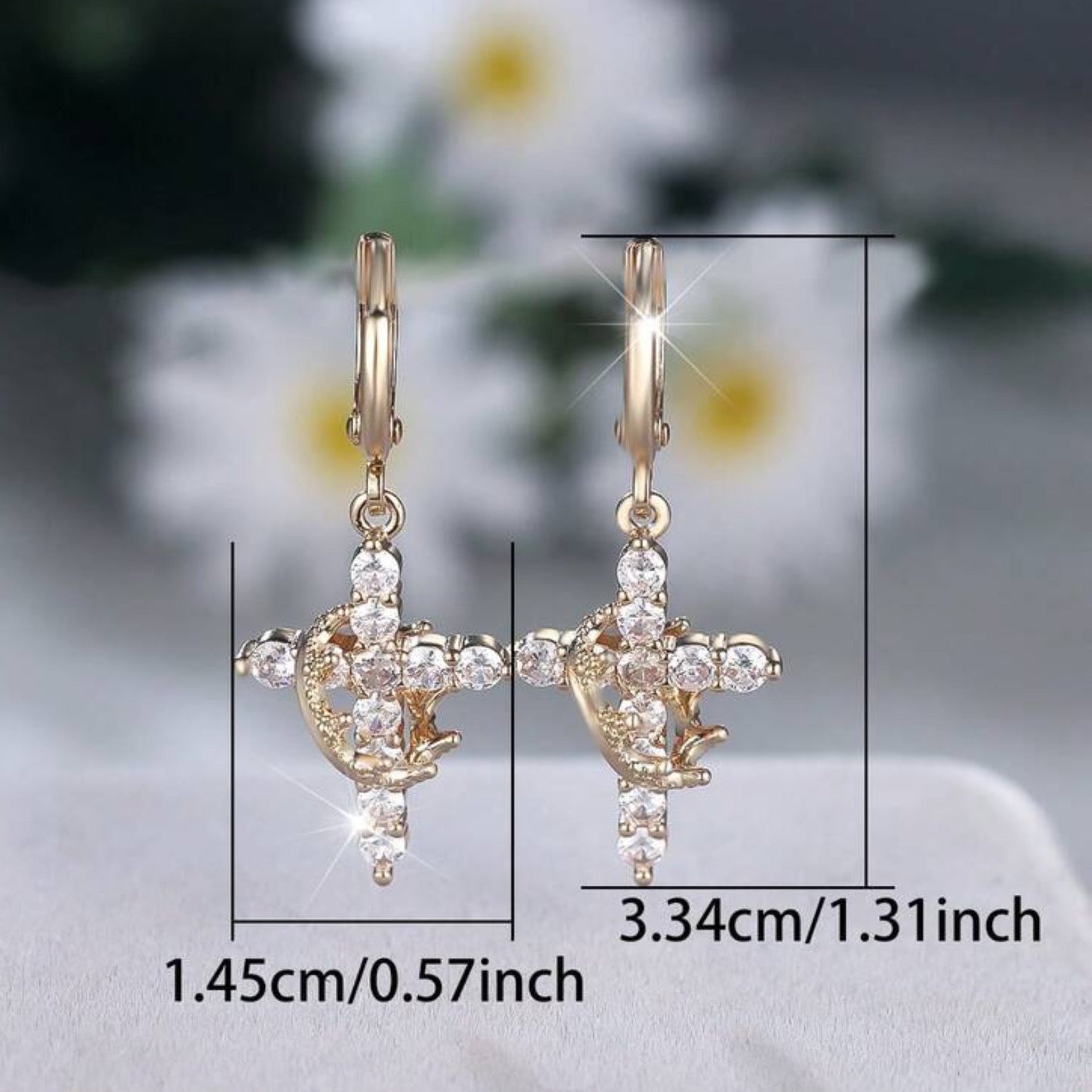 Gold Cross Crown earrings with cubic zirconia stones and measurements on a blurred floral background