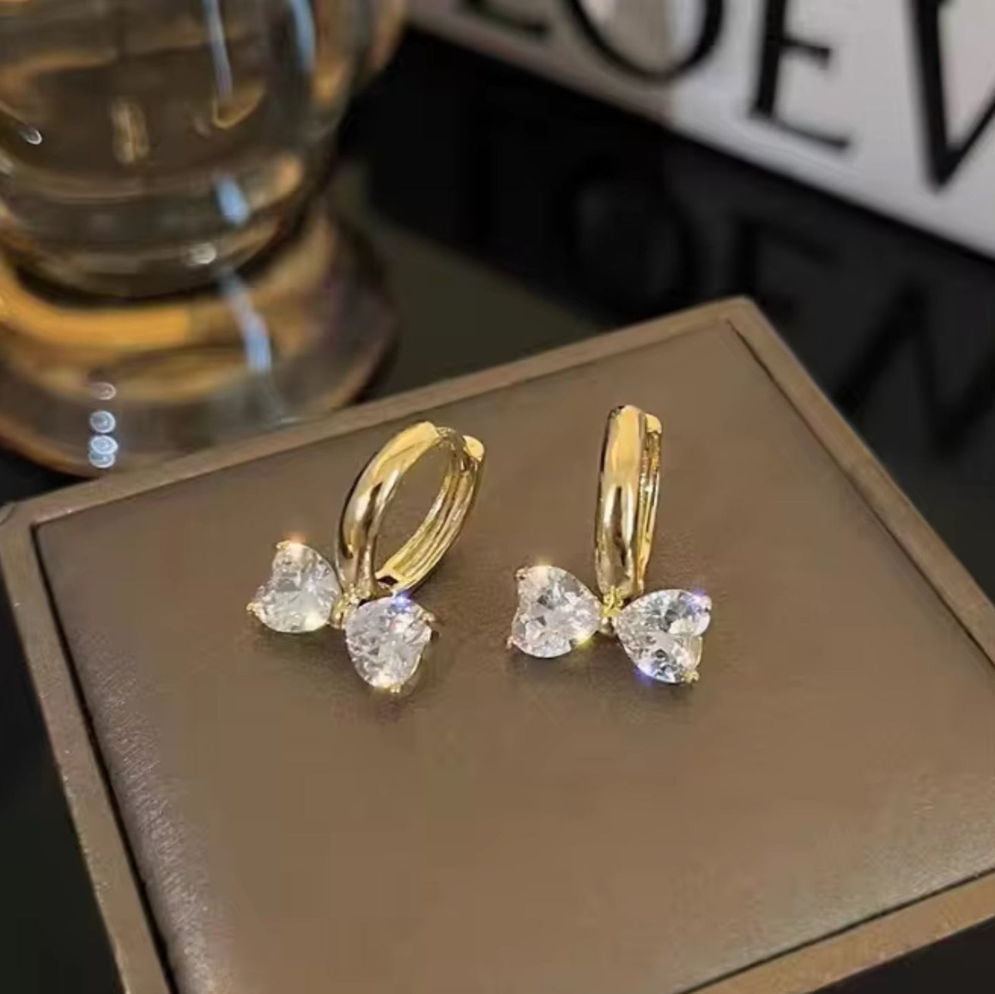 Gold Zircon Bow Hoop Earrings on a brown box