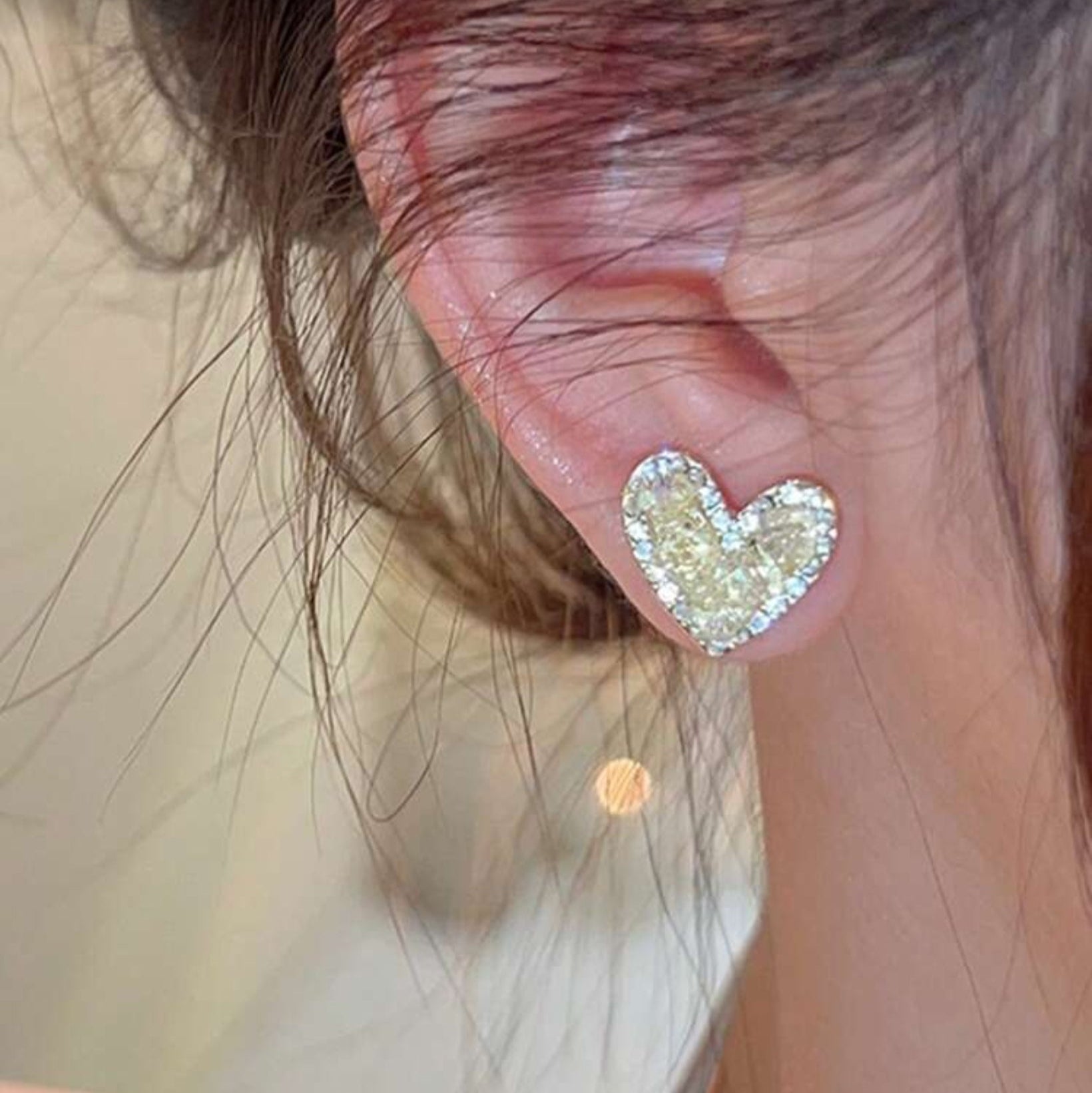 Champagne Heart Earrings worn by a person