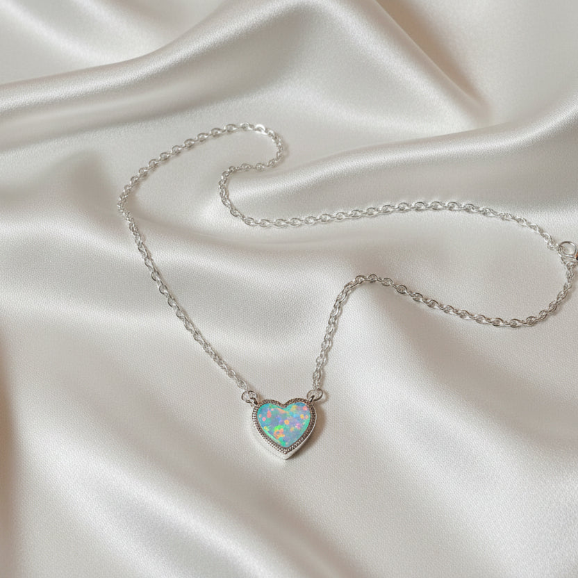 Iridescent Opal Heart Necklace on a silver chain against a light gray background
