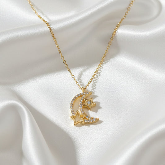 Gold necklace with moon and star pendant on a light blue background