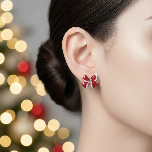 Red Rhinestone Bow Earrings worn by a person with a blurred background