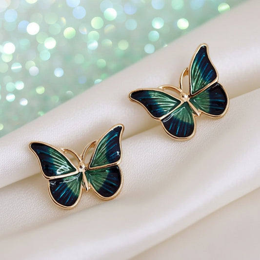 Blue & Green Butterfly Earrings on a beige fabric background