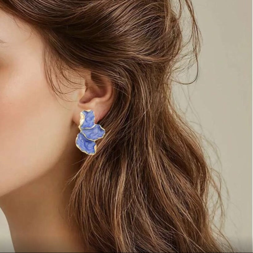 Close-up of a woman wearing the Blue Marble Petal Earrings