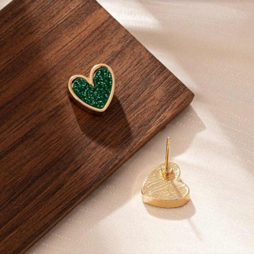 Green Glitter Heart Earrings on a wooden surface