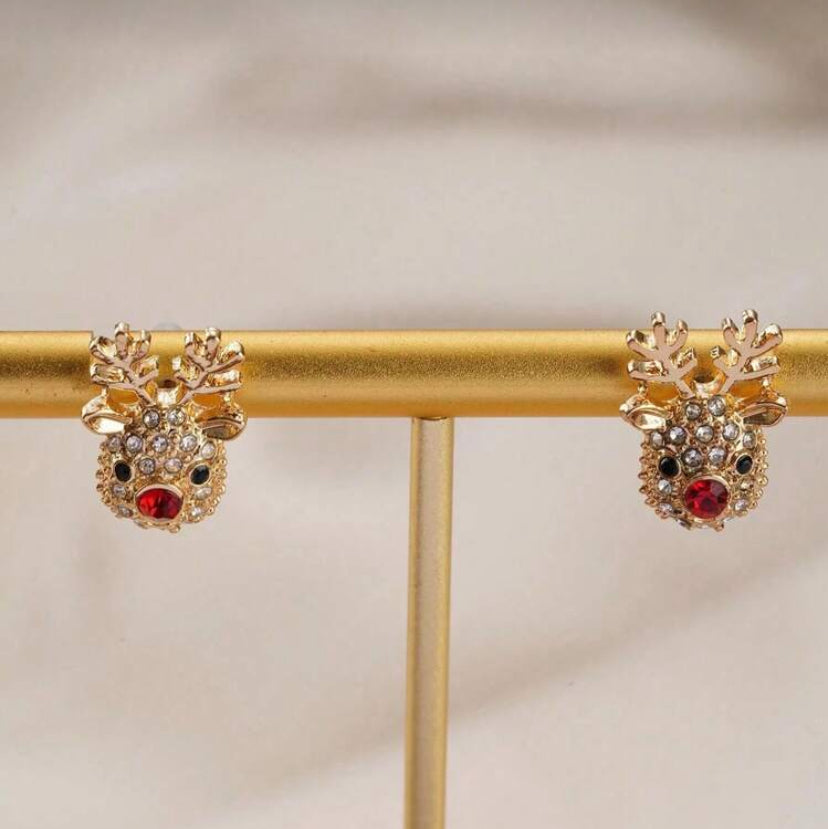 Rudolph Red Nose Reindeer Earrings on a gold stand against a beige background