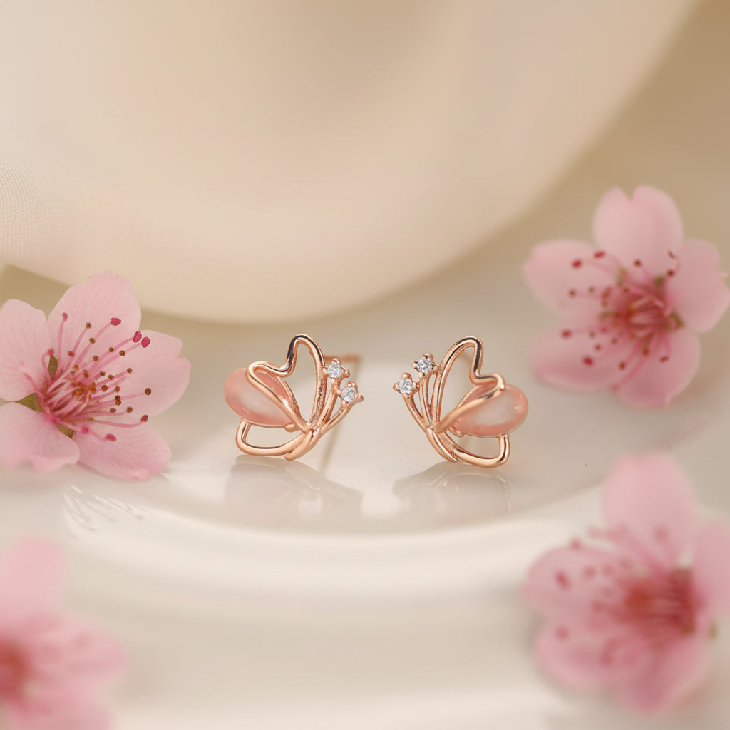 Rose Gold Butterfly Pearl Earrings with pink flowers on a soft beige background