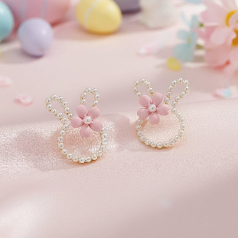 Pearl Bunny Blossom Earrings with pink flowers and pearl details on a soft pink background