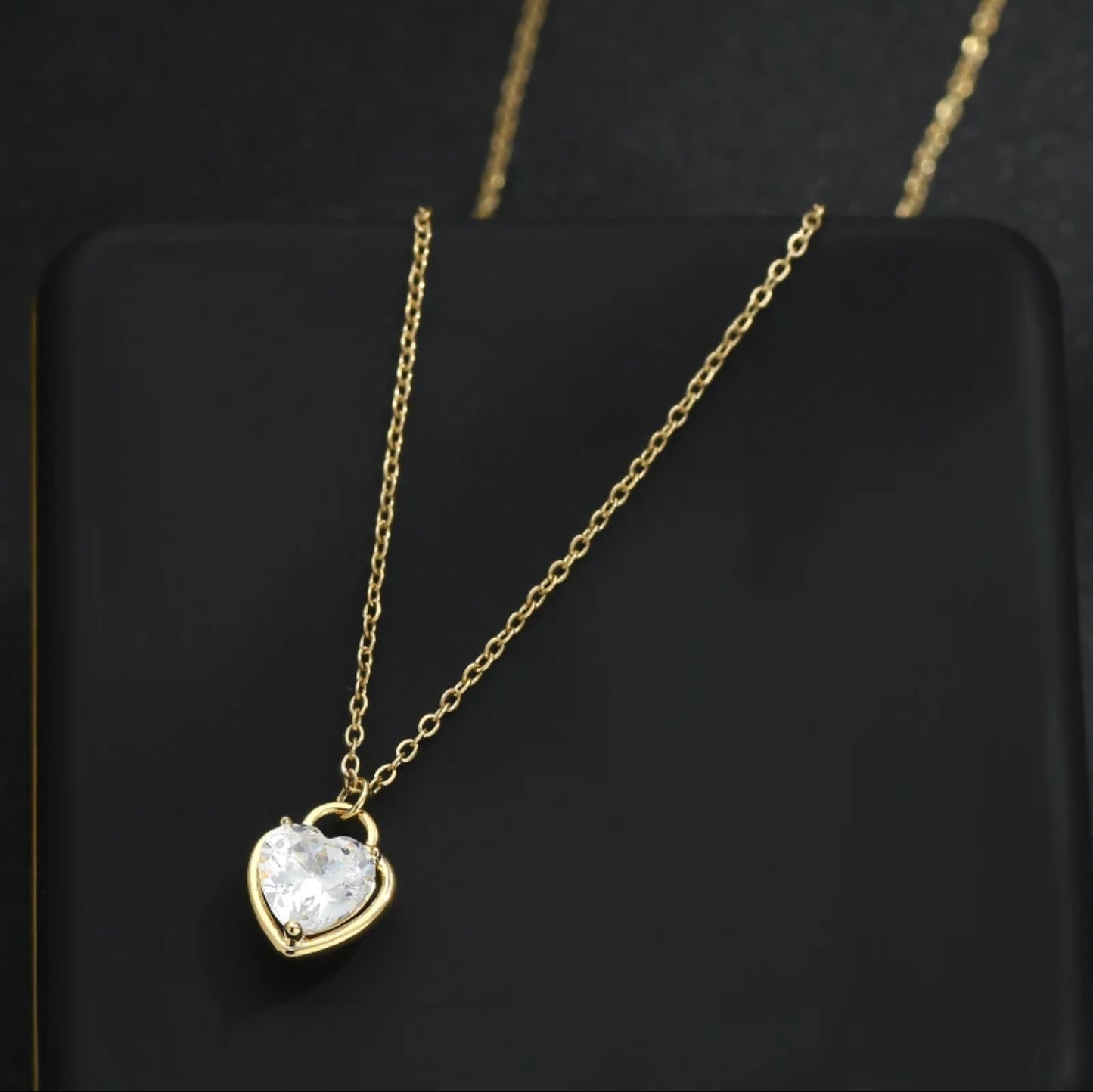 Zircon Heart Locket Necklace featuring a heart-shaped locket with sparkling zircons and an adjustable 16"-18" chain, on black jewelry box.