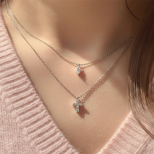 Close-up of layered Mini Cross Rhinestone Necklace styled with different outfits, demonstrating its versatility and elegant appeal.