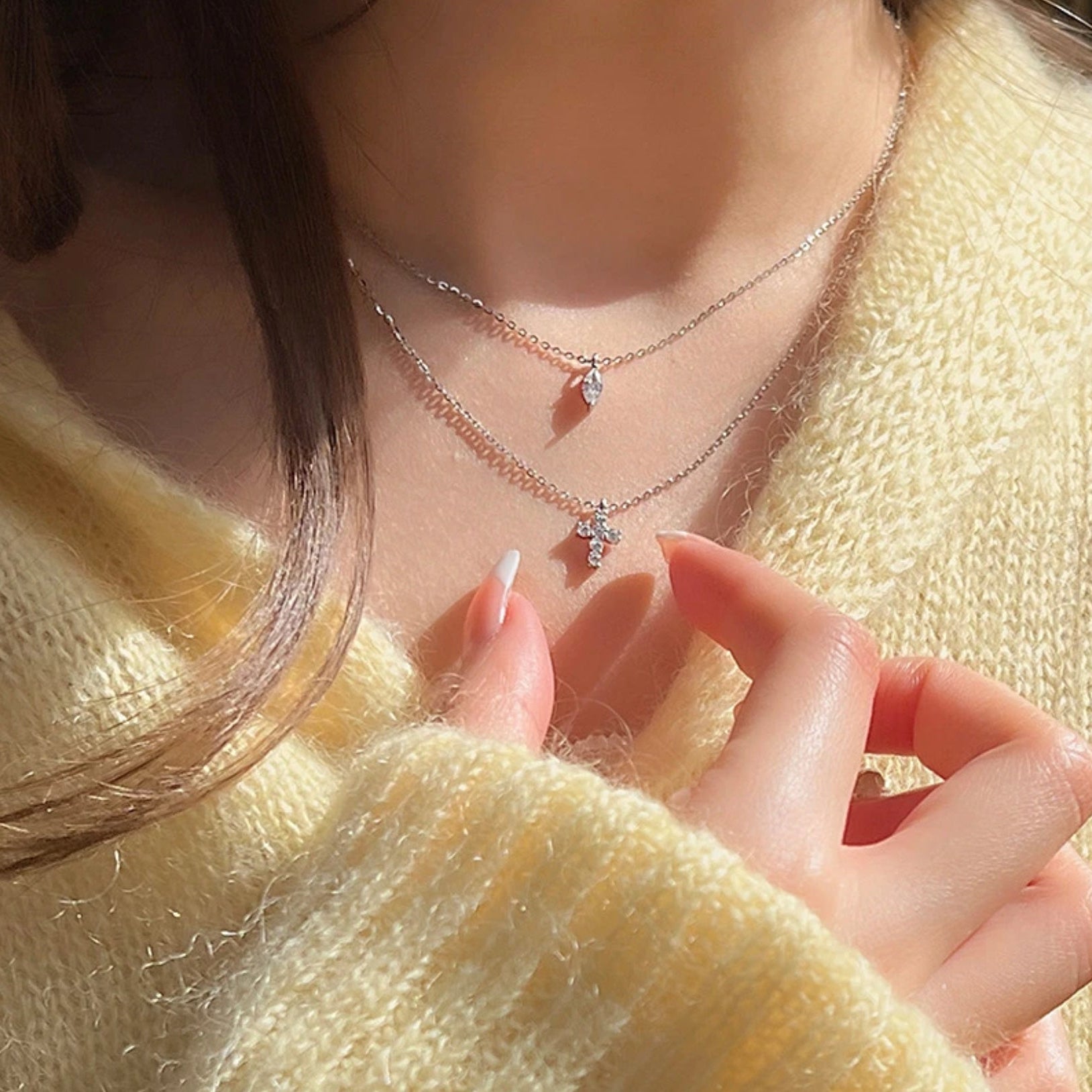 Layered Mini Cross Rhinestone Necklace styled with different outfits, demonstrating its versatility and elegant appeal, yellow sweater.