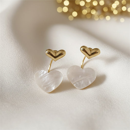 Mother of Pearl Double Heart Drop Earrings on a fabric background