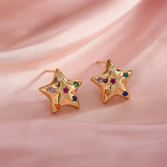 Multicolor Twinkle Star Earrings with colorful gemstones on a pink fabric background