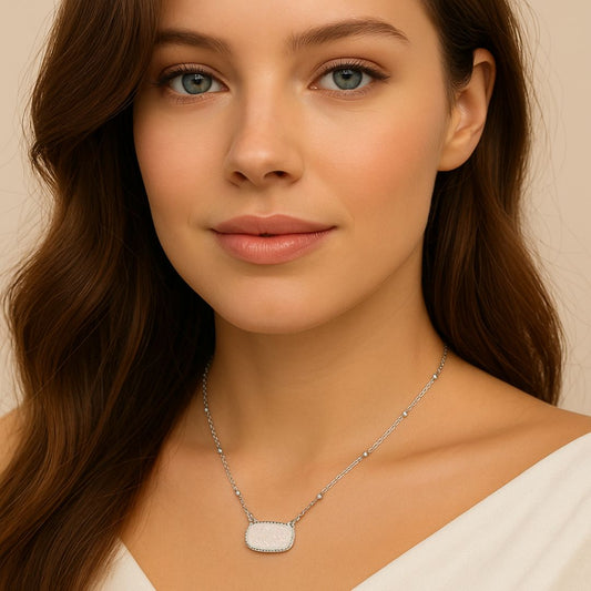Woman wearing a White Opal Druzy Glow Pendant Silver Necklacewith a beige background