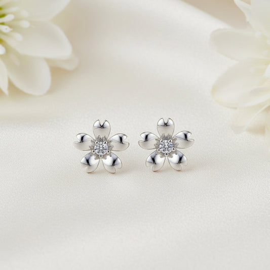 Silver Zirconia Flower Earrings with clear stones on a white floral background