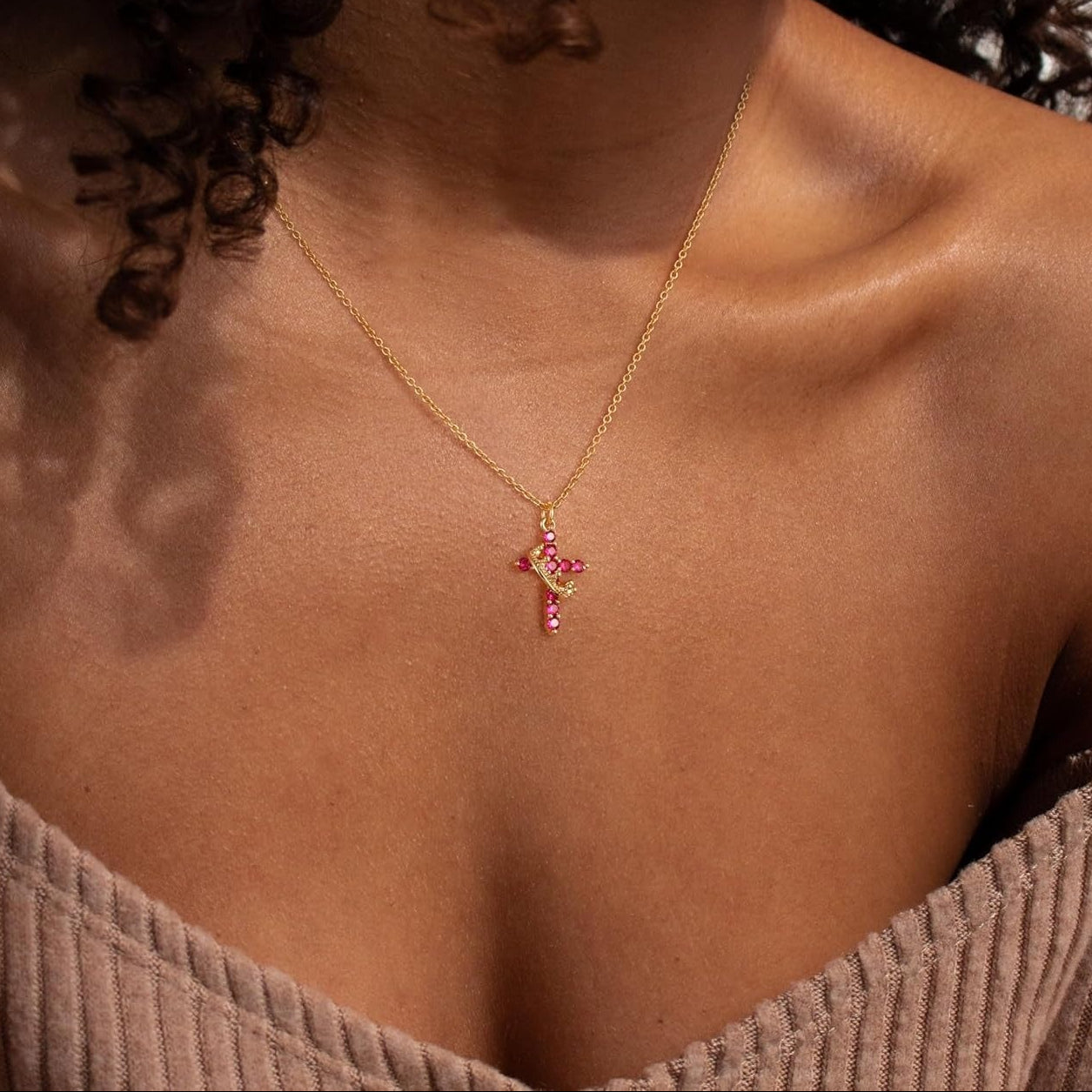 Woman wearing a Pink & Gold Cross Crown Faith Necklace against a neutral background